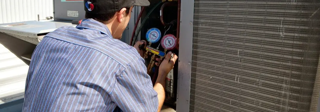 HVAC technician servicing a condenser unit in South San Francisco